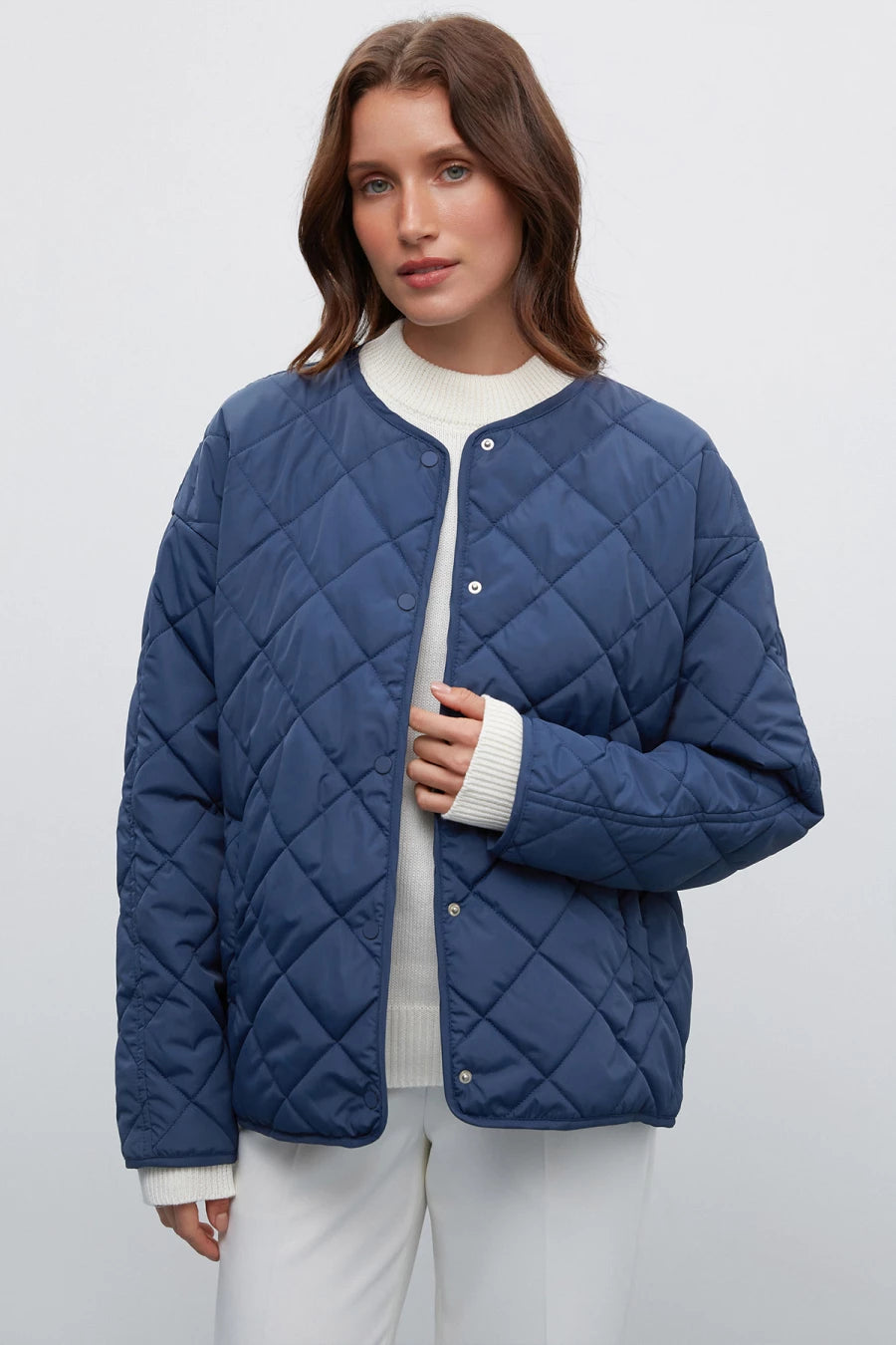 Dark blue quilted jacket with a free cut